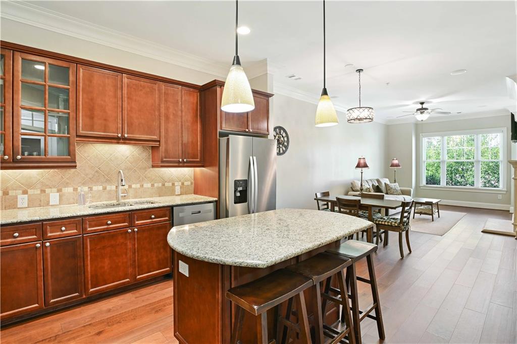 3635 East Paces Circle, Unit 1410 Atlanta, GA 30326 - Photo 14 of 68 a kitchen with stainless steel appliances granite countertop a kitchen island a table and chairs in it