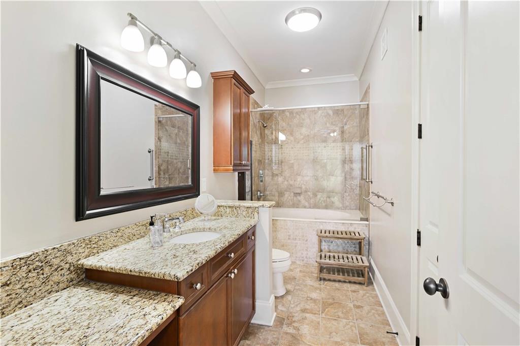 3635 East Paces Circle, Unit 1410 Atlanta, GA 30326 - Photo 26 of 68 a bathroom with a granite countertop sink mirror and a bathtub
