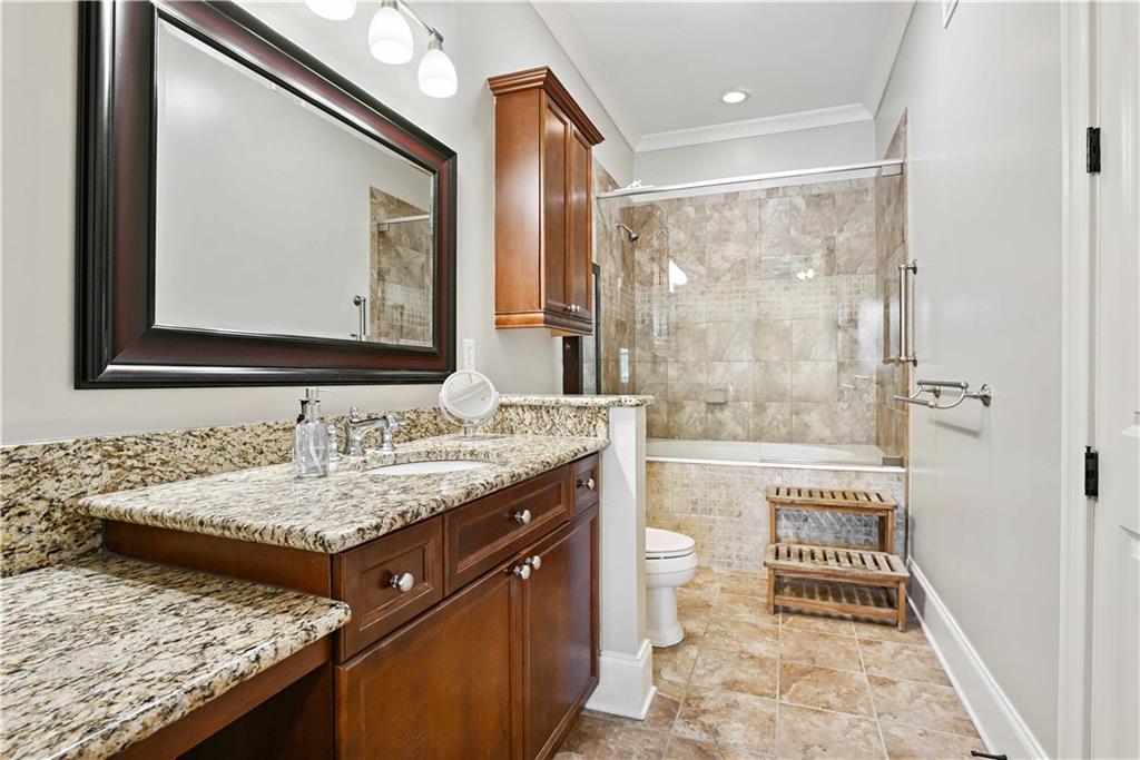 3635 East Paces Circle, Unit 1410 Atlanta, GA 30326 - Photo 27 of 68 a bathroom with a granite countertop sink and a mirror