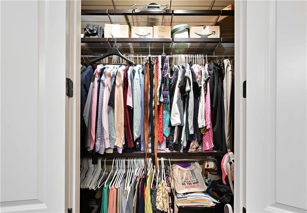 3635 East Paces Circle, Unit 1410 Atlanta, GA 30326 - Photo 32 of 68 a view of walk in closet with clothes