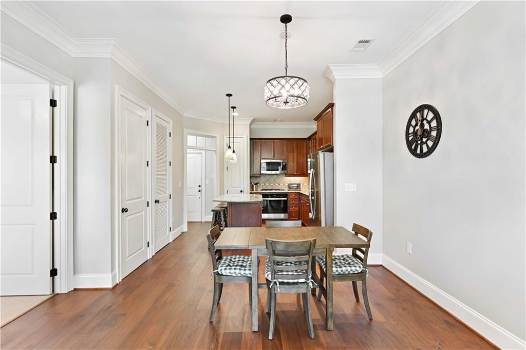 3635 East Paces Circle, Unit 1410 Atlanta, GA 30326 - Photo 8 of 68 a view of a dining room with furniture wooden floor and a clock