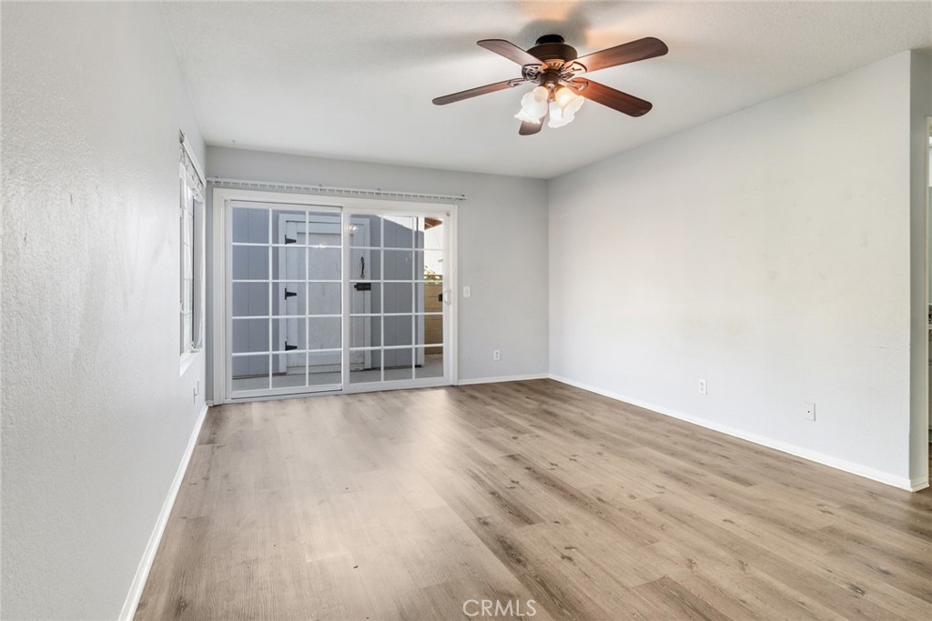 8358 Garden Street Rancho Cucamonga, CA 91701 - Photo 18 of 28 an empty room with wooden floor chandelier fan and windows