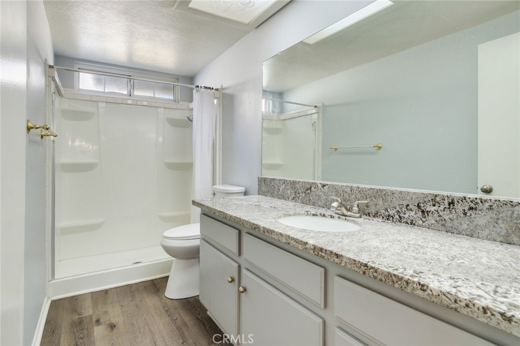 8358 Garden Street Rancho Cucamonga, CA 91701 - Photo 20 of 28 a bathroom with a granite countertop sink a toilet and shower
