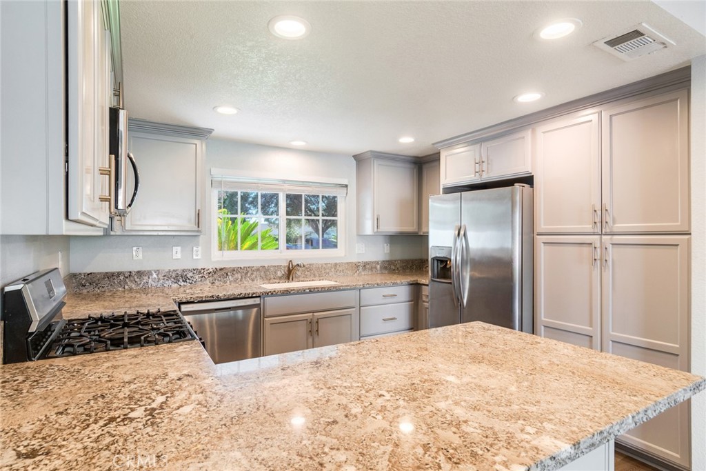 8358 Garden Street Rancho Cucamonga, CA 91701 - Photo 8 of 28 a kitchen with stainless steel appliances granite countertop a refrigerator sink and stove