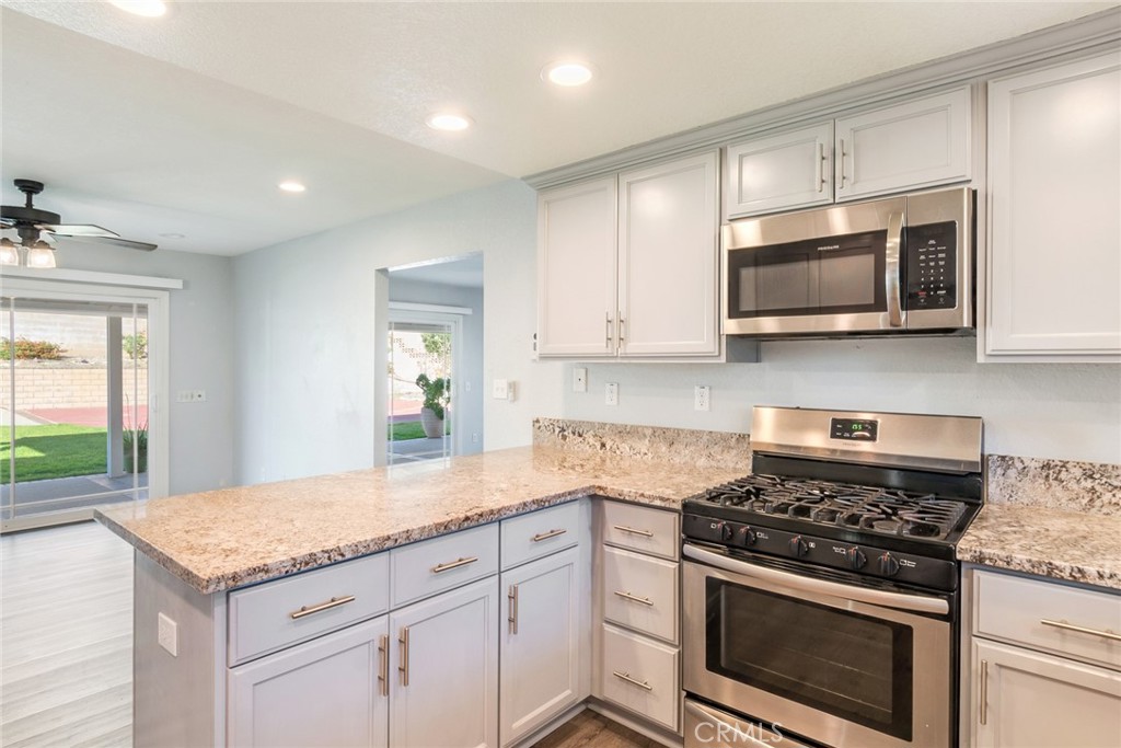 8358 Garden Street Rancho Cucamonga, CA 91701 - Photo 9 of 28 a kitchen with granite countertop a stove and a sink