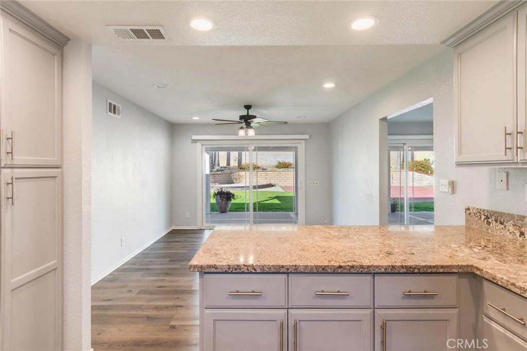 8358 Garden Street Rancho Cucamonga, CA 91701 - Photo 10 of 28 a kitchen with granite countertop kitchen island white cabinets and a granite counter tops