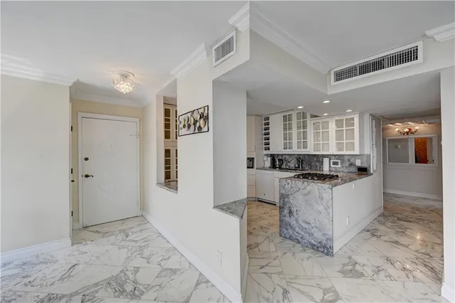 a large white kitchen with stainless steel appliances granite countertop a refrigerator and a stove