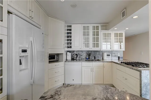 a kitchen with granite countertop a sink a stove and cabinets