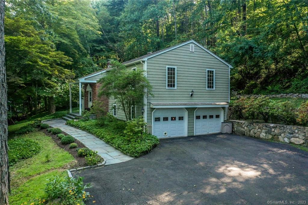 69 Fulling Mill Lane Ridgefield, CT 06877 - Photo 1 of 1 a front view of a house with a garden and trees