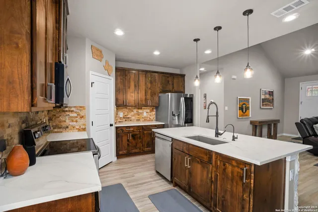 a kitchen with a sink a stove a refrigerator and a stove