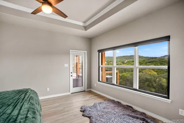 a view of an empty room and window and chandelier fan