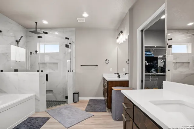 a bathroom with a tub sink shower and mirror