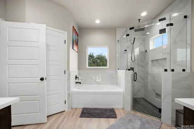 a spacious bathroom with a shower a bathtub and a shower