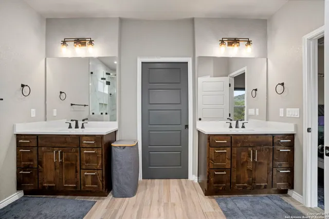 a spacious bathroom with a granite countertop sink a mirror and a shower