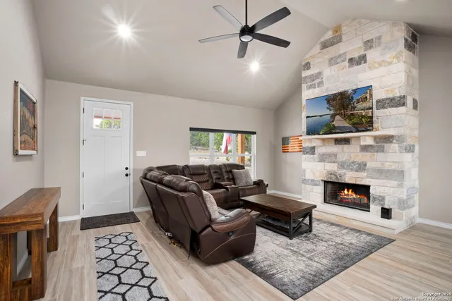a living room with furniture a flat screen tv and a fireplace
