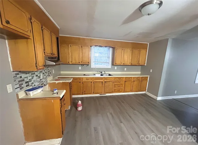 a view of a kitchen with wooden floor and cabinets