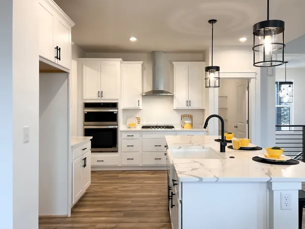 a kitchen with stainless steel appliances a sink a stove and cabinets