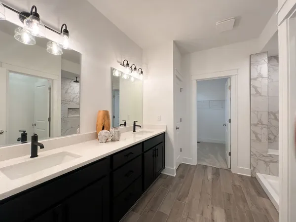 a bathroom with double vanity sinks and a mirror