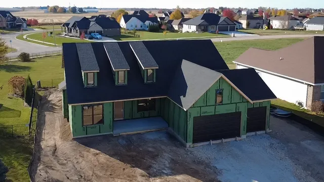 a aerial view of a house with a garden and lake view