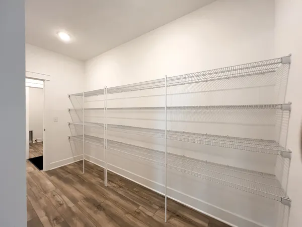 a view of a dining room and livingroom with furniture wooden floor a chandelier