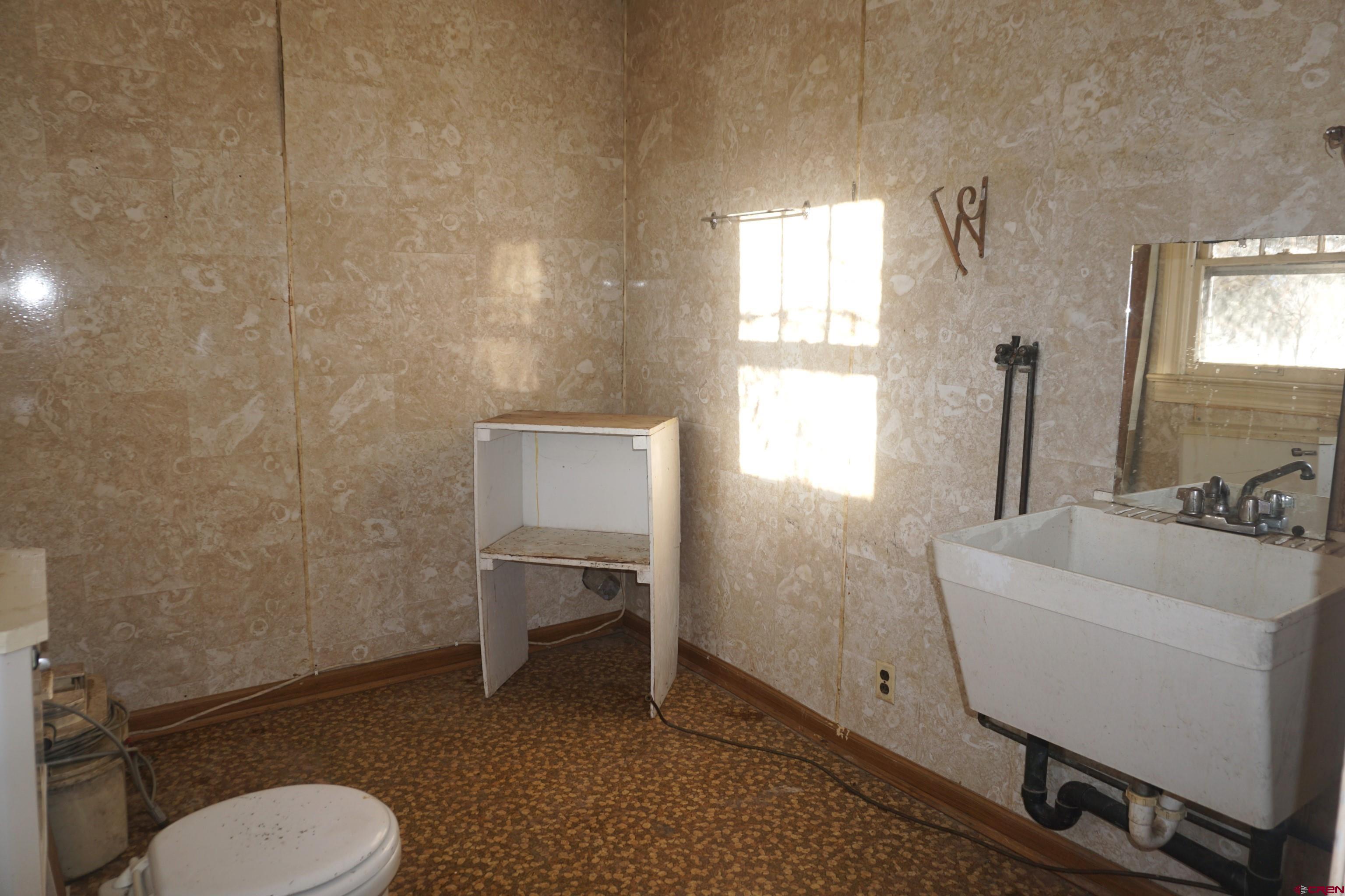 19235 2325th Road Cedaredge, CO 81413 - Photo 16 of 34 a bathroom with a toilet a sink and mirror