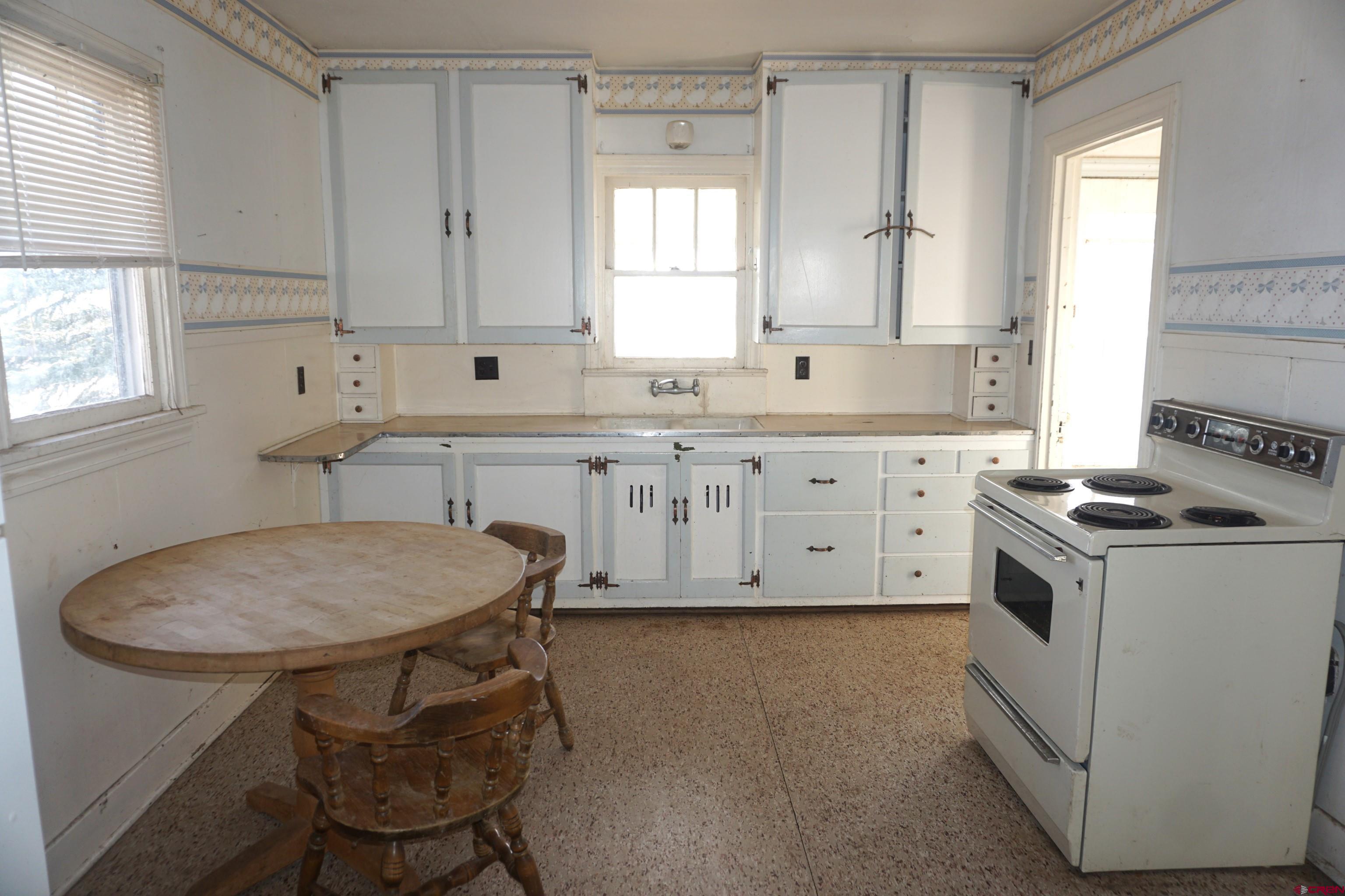 19235 2325th Road Cedaredge, CO 81413 - Photo 9 of 34 a kitchen with a stove a sink and a refrigerator