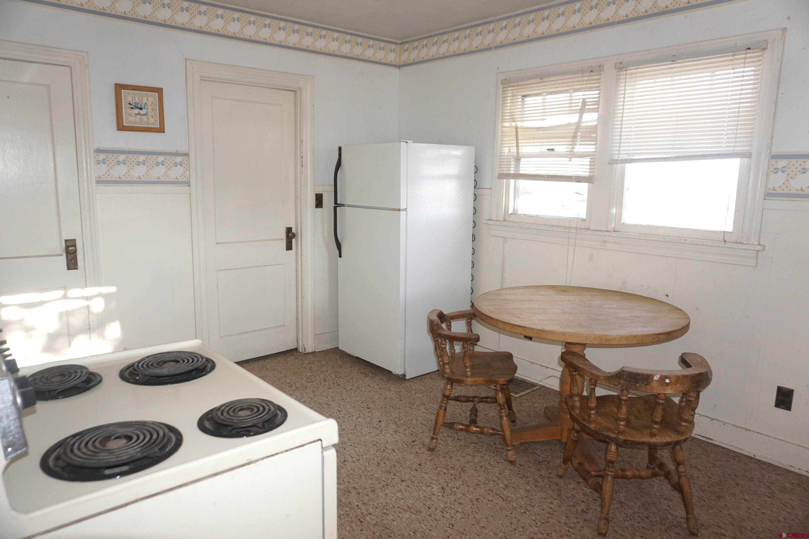 19235 2325th Road Cedaredge, CO 81413 - Photo 10 of 34 a kitchen with a refrigerator and a stove top oven