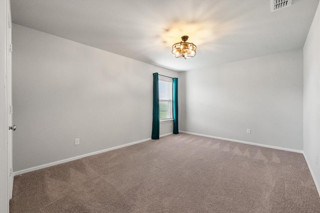 6910 Prairieside Trail Venus, TX 76084 - Photo 31 of 40 This spacious room features neutral-toned carpet, light gray walls, and a window with blinds and walk-in closet!