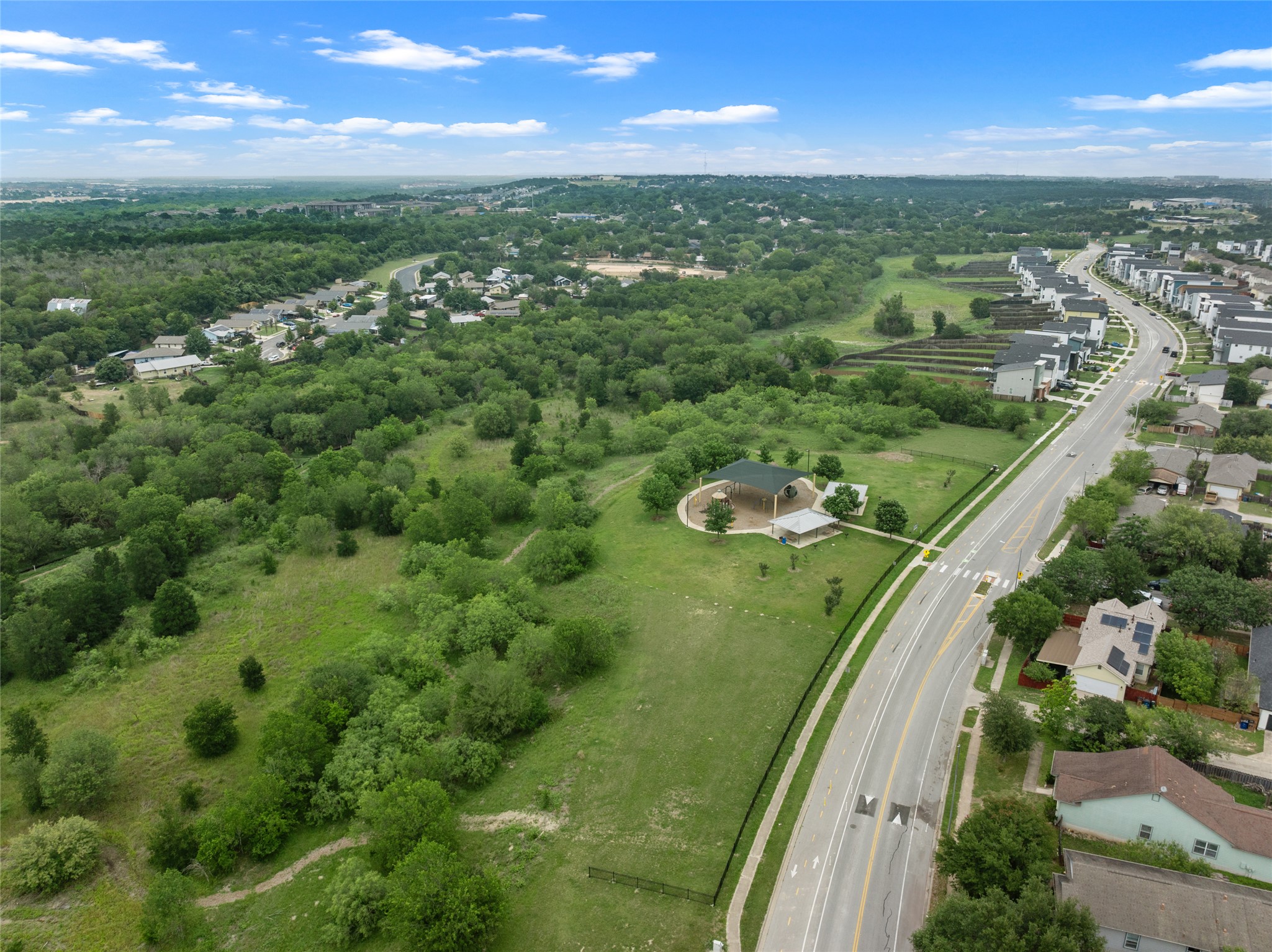 5613 Signal Point Austin, TX 78724 - Photo 20 of 21 Expansive green space featuring a paved walkway, a covered pavilion, and surrounding mature trees