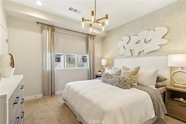 a bedroom with a large bed and a chandelier