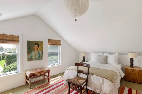 a bedroom with two beds and a large window