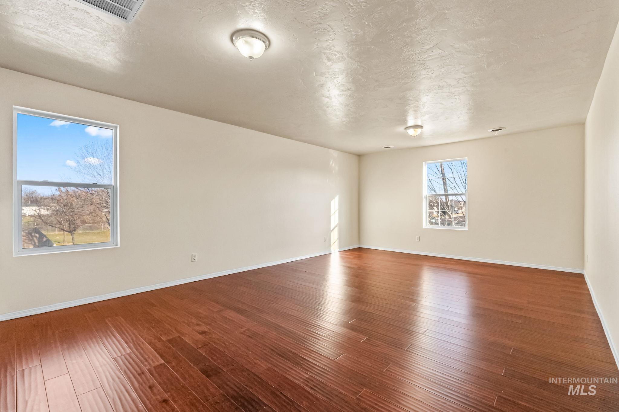 4523 Duke Street Caldwell, ID 83607 - Photo 14 of 27 Unfurnished room featuring a textured ceiling and wood finished floors