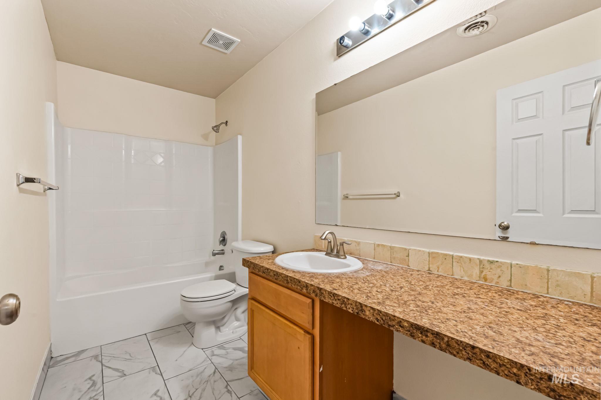 4523 Duke Street Caldwell, ID 83607 - Photo 23 of 27 Bathroom featuring vanity, tub / shower combination, and light marble finish flooring