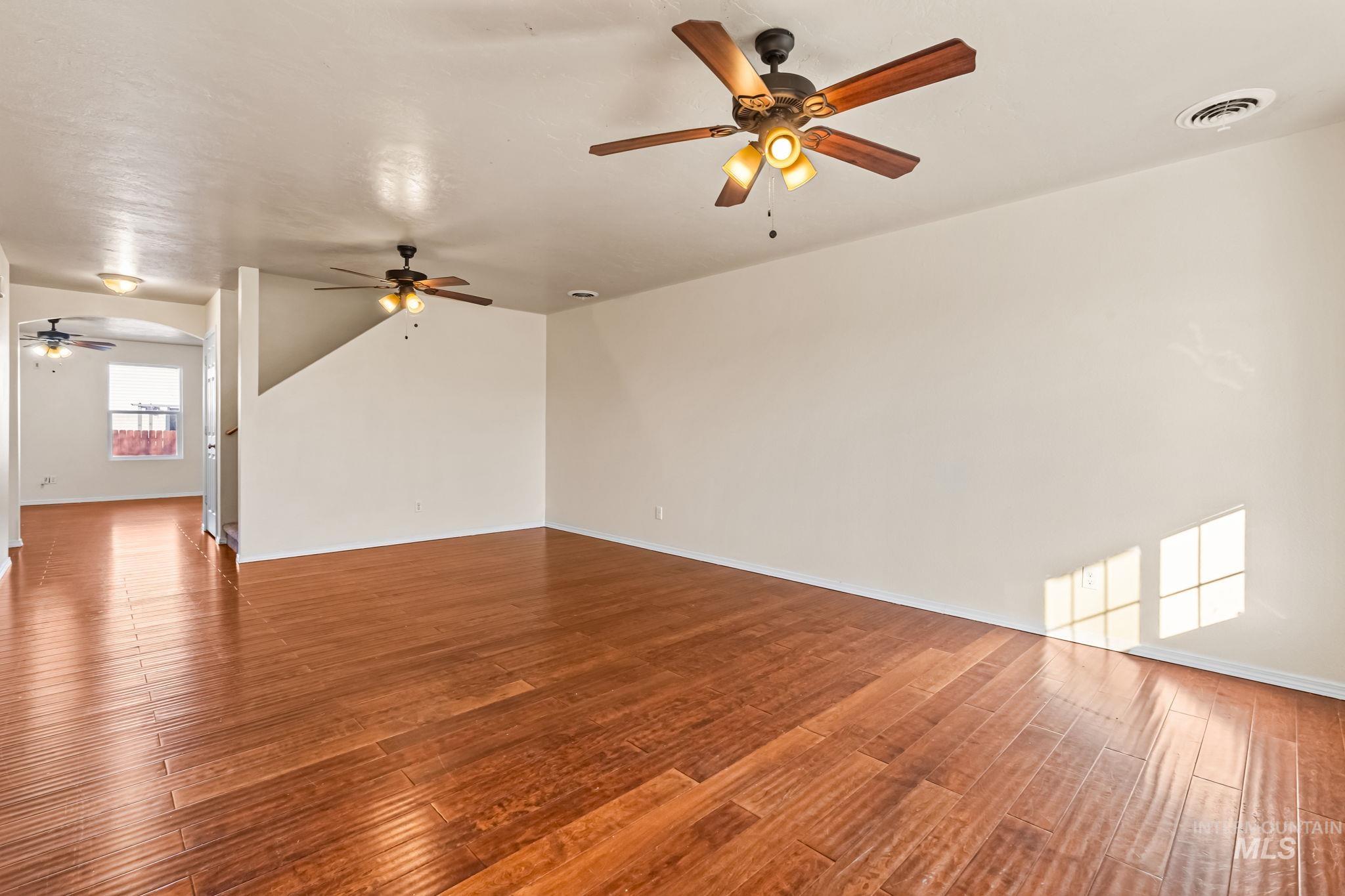 4523 Duke Street Caldwell, ID 83607 - Photo 4 of 27 Spare room with a ceiling fan, wood finished floors, and arched walkways
