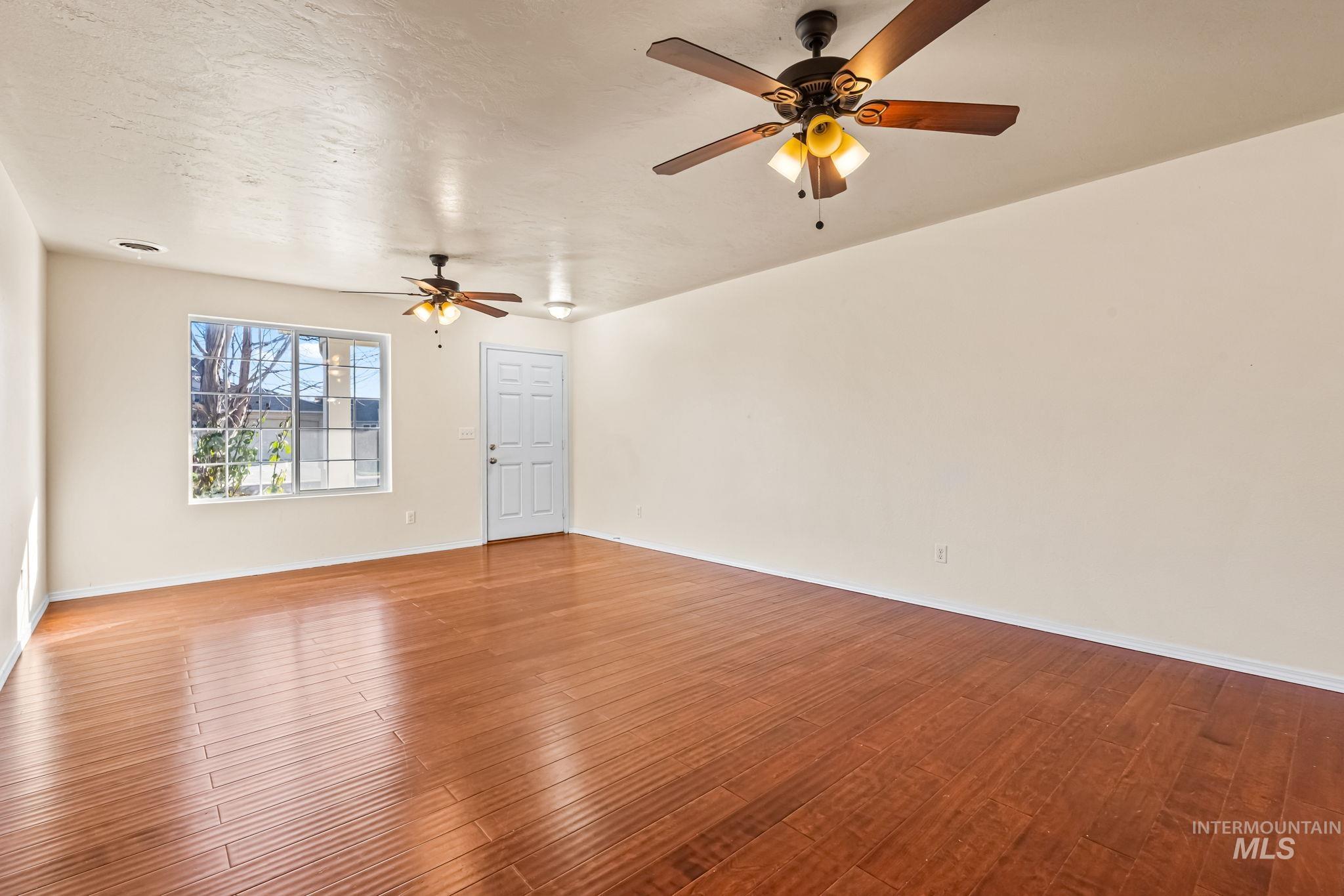 4523 Duke Street Caldwell, ID 83607 - Photo 5 of 27 Unfurnished room featuring wood finished floors, a textured ceiling, and ceiling fan