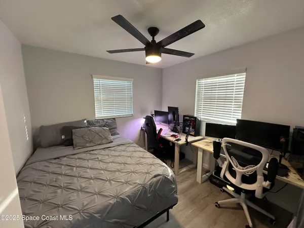 a bedroom with a bed and a ceiling fan