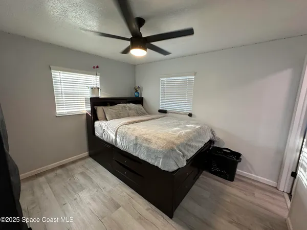 a bedroom with a bed and a ceiling fan
