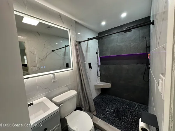 a bathroom with a toilet and a shower