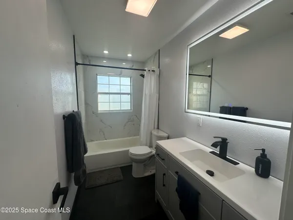 a bathroom with a double vanity sink toilet and shower