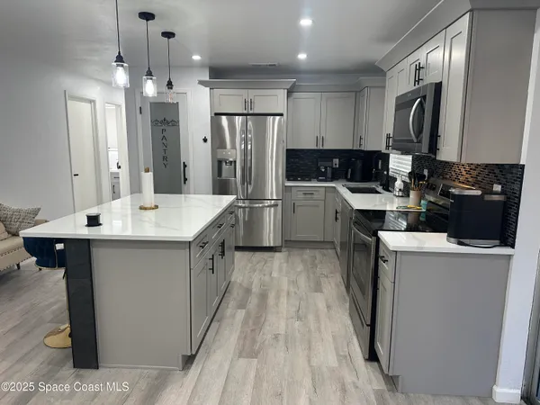 a kitchen with refrigerator and cabinets