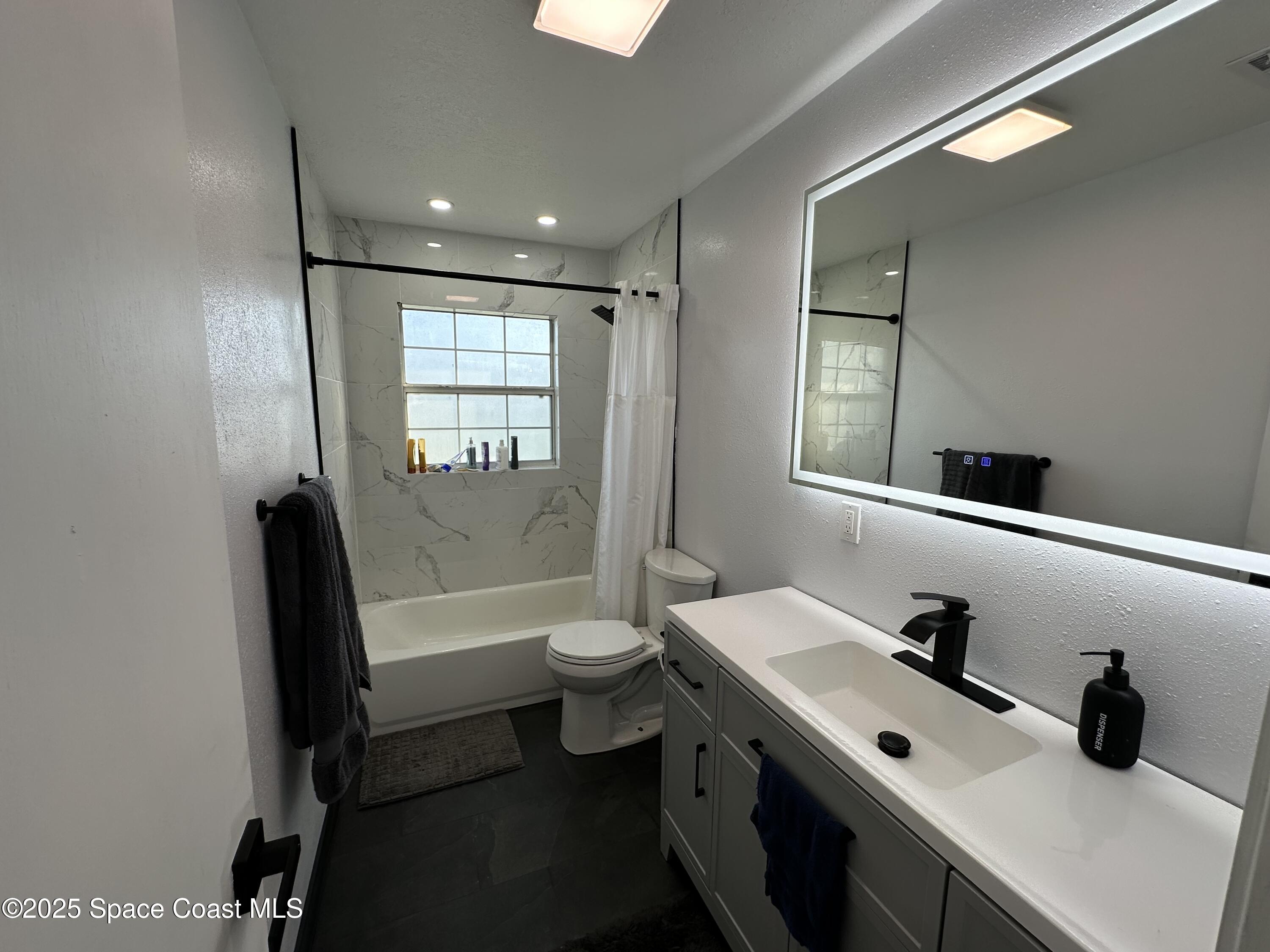 3782 Catalina Drive Cocoa, FL 32926 - Photo 10 of 17 a bathroom with a double vanity sink toilet mirror and bathtub