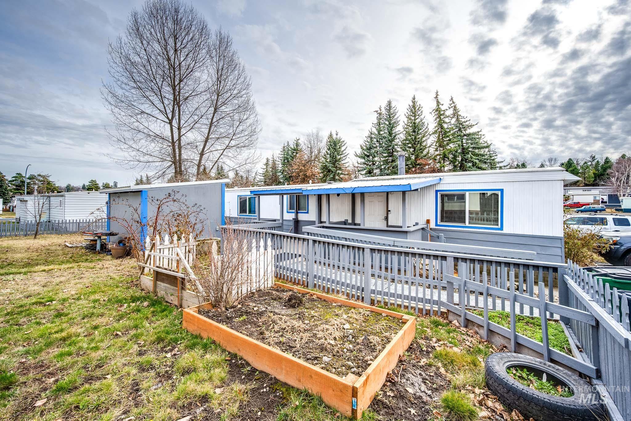 Rear view of house with a vegetable garden and a wooden deck