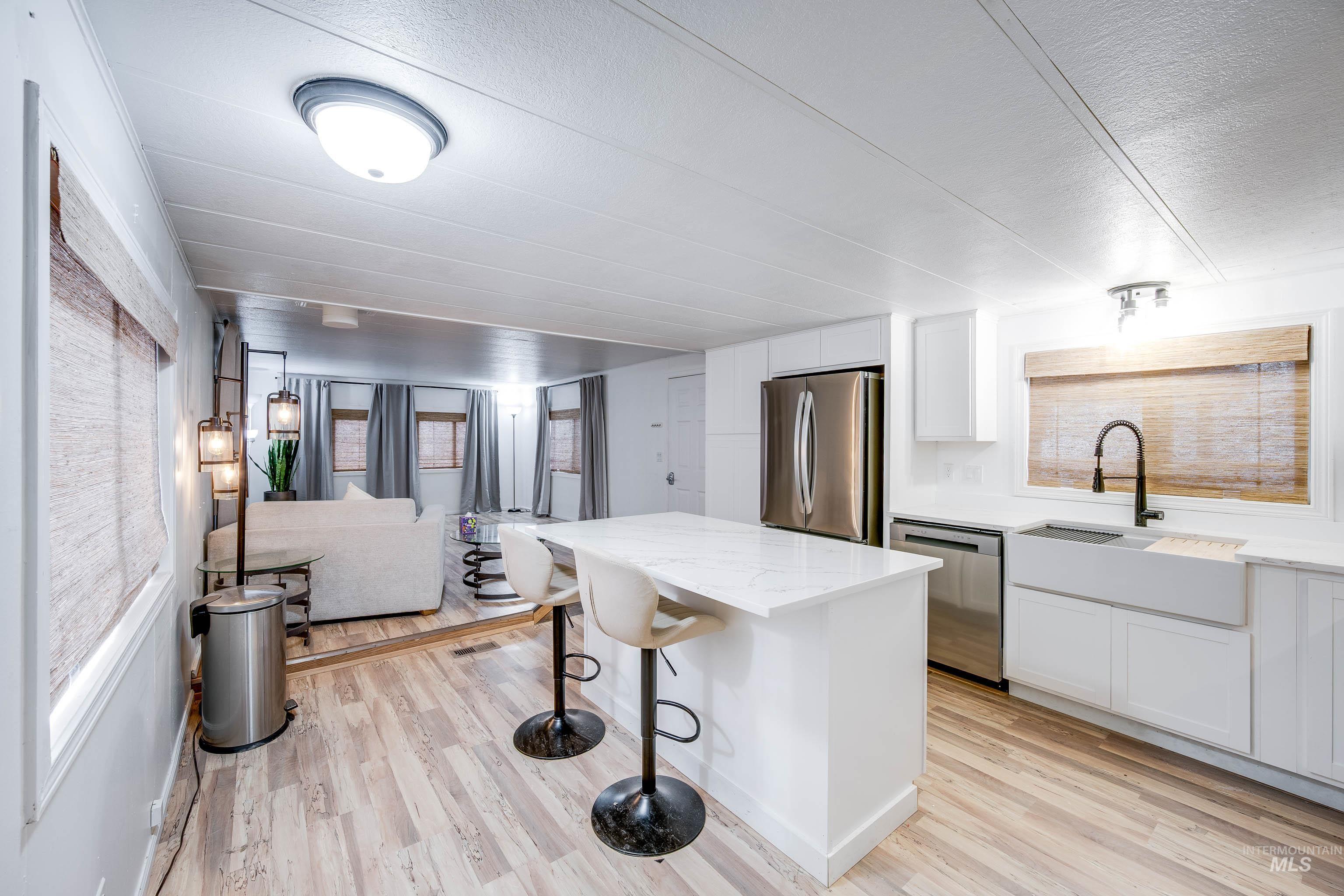 411 North Almon Street, Unit 304 Moscow, ID 83843 - Photo 21 of 21 Kitchen with white cabinets, a breakfast bar area, stainless steel appliances, and open floor plan