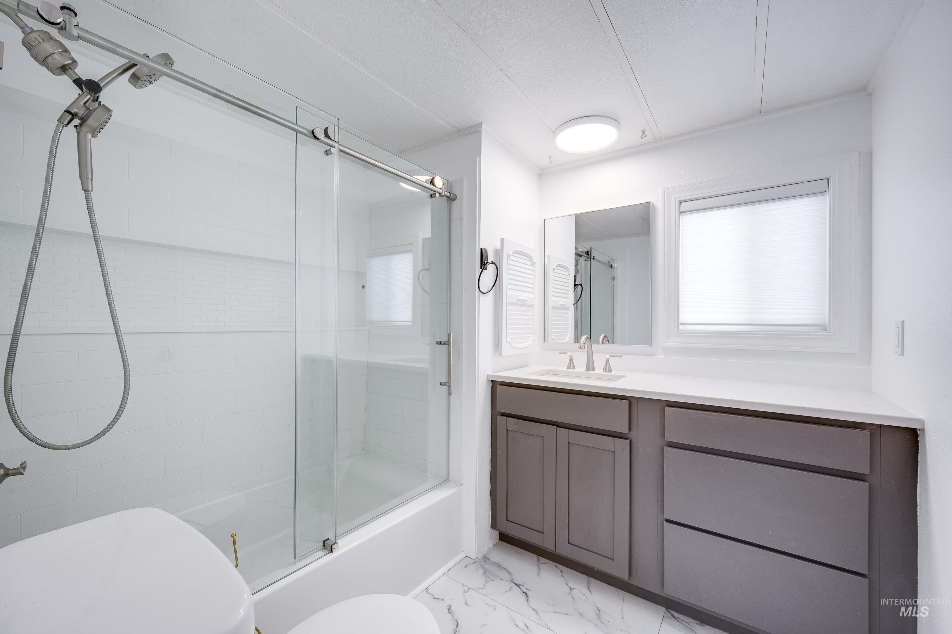 411 North Almon Street, Unit 304 Moscow, ID 83843 - Photo 13 of 21 Bathroom featuring combined bath / shower with glass door, vanity, and light marble finish flooring