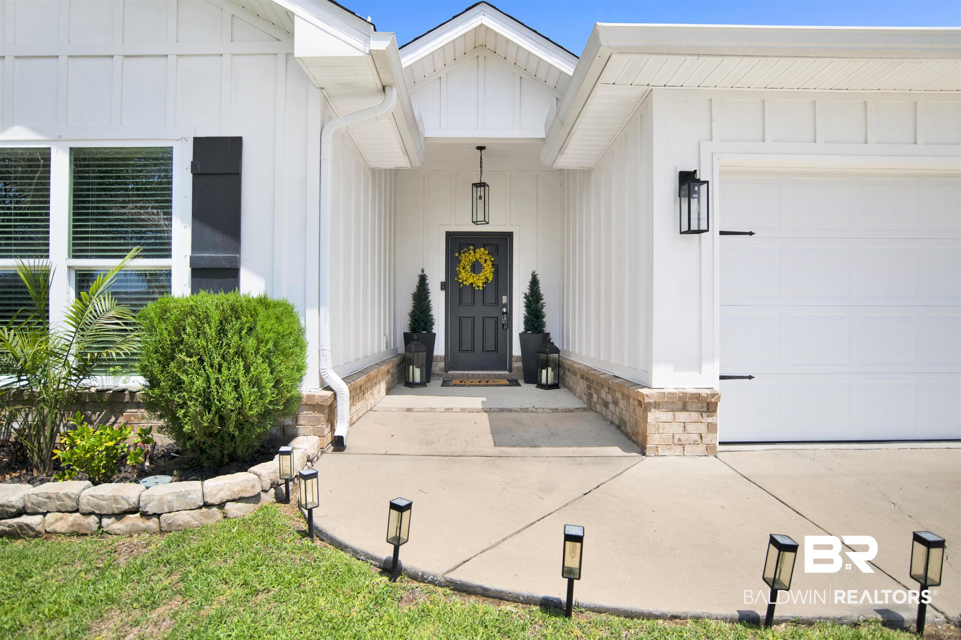 8493 Bronze Lane Foley, AL 36535 - Photo 2 of 38 Modern farmhouse exterior with white board-and-batten siding and a grey entry door