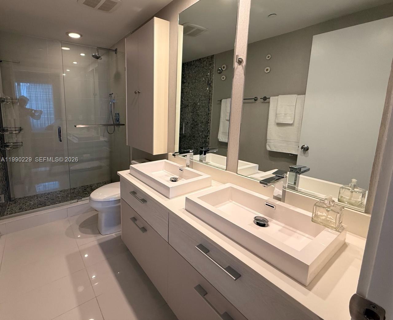 45 Southwest 9th Street, Unit 1401 Miami, FL 33130 - Photo 11 of 17 a bathroom with a sink double vanity and a toilet