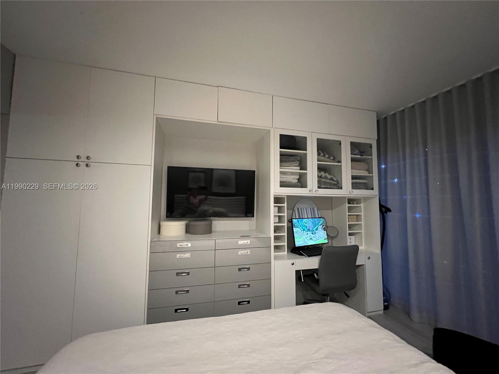 45 Southwest 9th Street, Unit 1401 Miami, FL 33130 - Photo 15 of 17 a room with a bed and a television in it