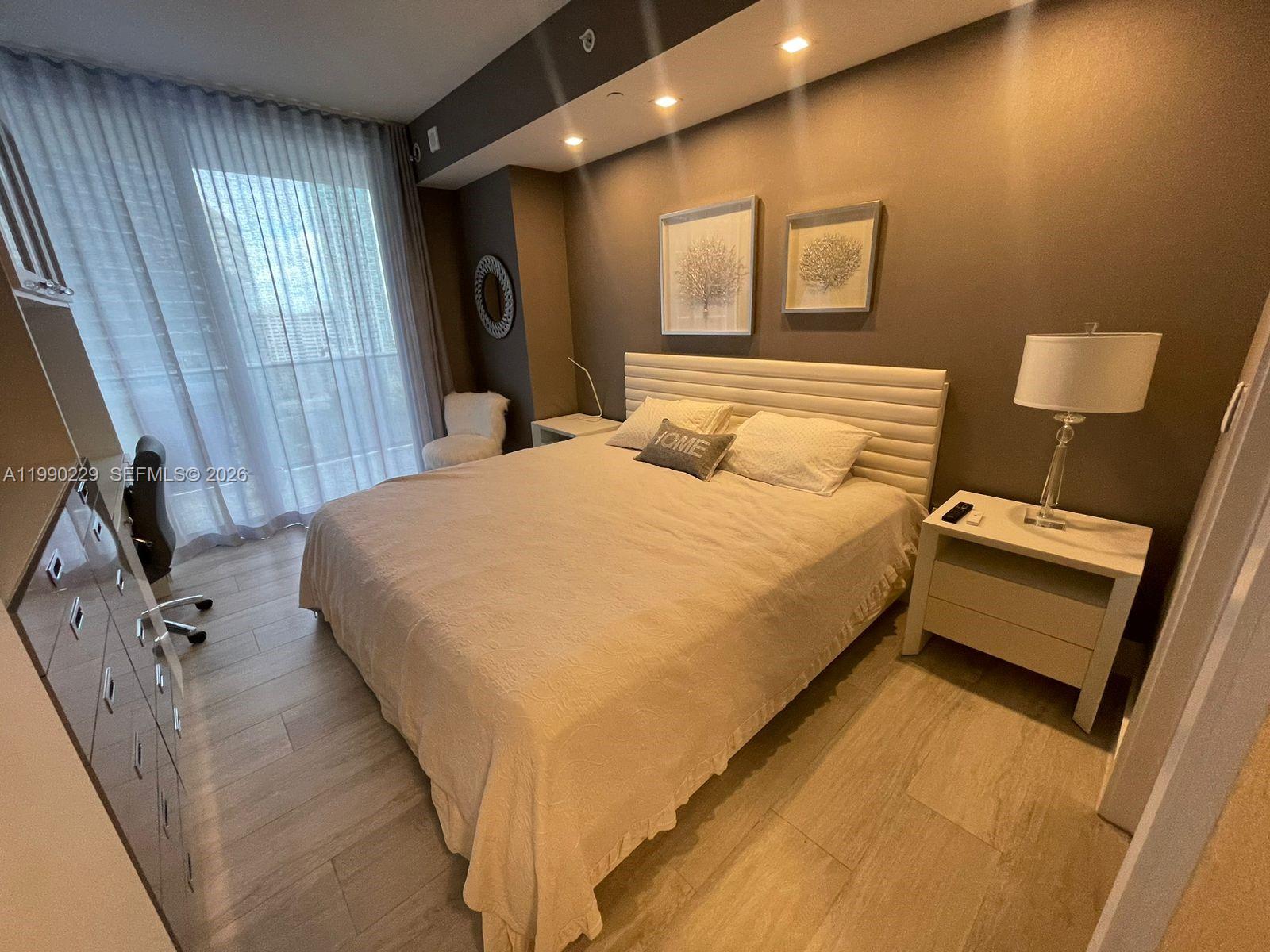 45 Southwest 9th Street, Unit 1401 Miami, FL 33130 - Photo 17 of 17 a bedroom with a bed and a flat tv screen on dresser