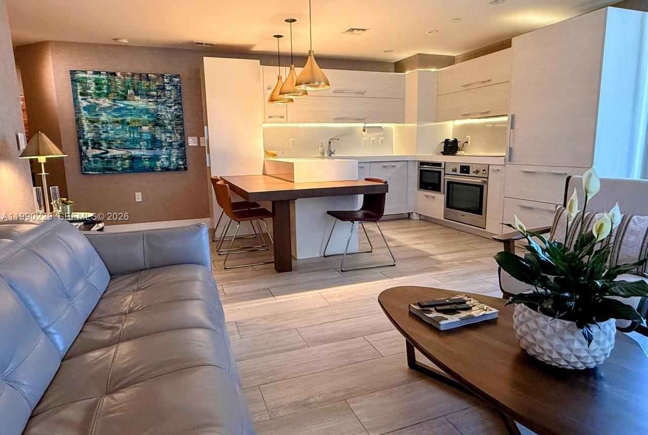 45 Southwest 9th Street, Unit 1401 Miami, FL 33130 - Photo 3 of 17 a living room with furniture kitchen area and a large window