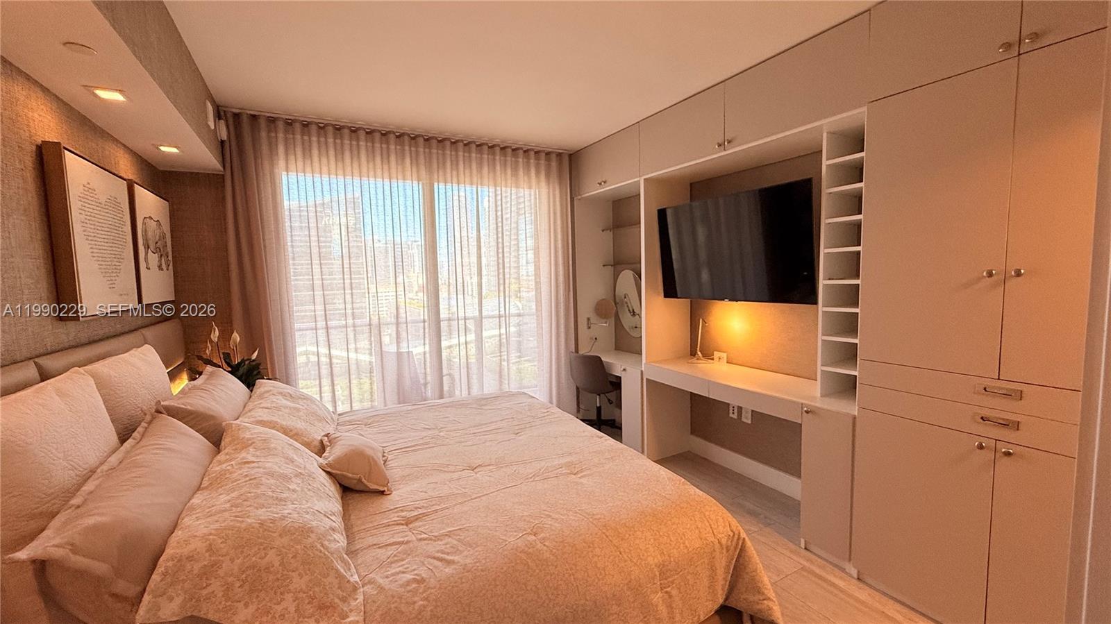 45 Southwest 9th Street, Unit 1401 Miami, FL 33130 - Photo 9 of 17 a bedroom with a bed and a flat screen tv